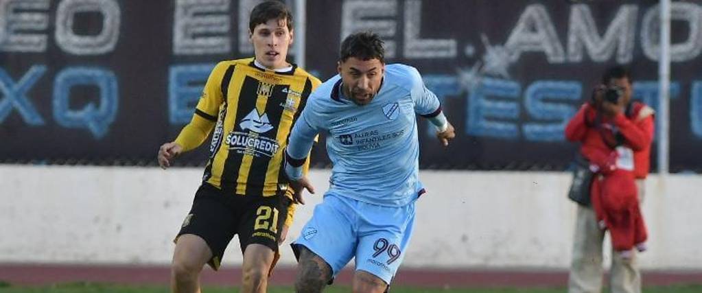 El atigrado Fabricio Quaglio (izq.) lucha por el balón con Damián Batallini.