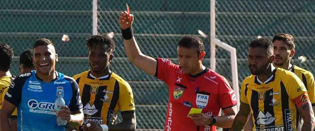 El árbitro Gery Vargas le muestra la tarjeta roja al defensor de Blooming Julio Vila. 