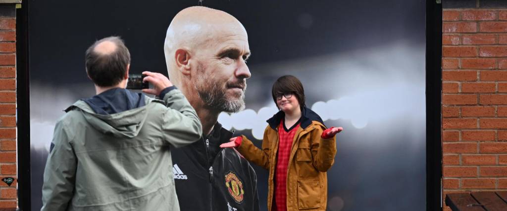 Un hincha reacciona mientras posa frente a una foto del recién despedido entrenador holandés del Manchester United, Erik ten Hag, fuera de Old Trafford, en Manchester