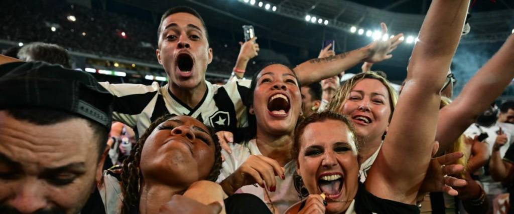 Fans of Botafogo celebrate after their team won the Copa Libertadores final match between Atletico Mineiro and Botafogo, held in Buenos Aires, at the Nilton Santos stadium in Rio de Janeiro, Brazil, on November 30, 2024. (Photo by Pablo PORCIUNCULA / AFP)