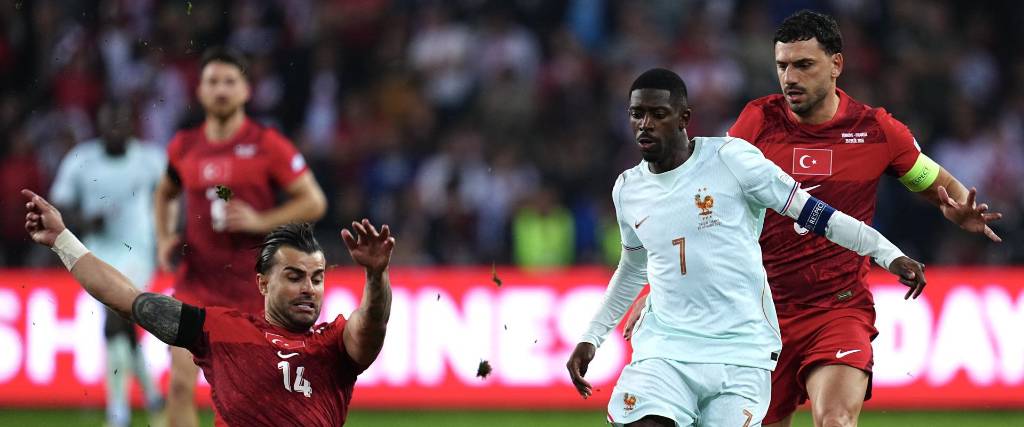 Ousmane Dembele (de blanco) frente a jugadores de Turquía