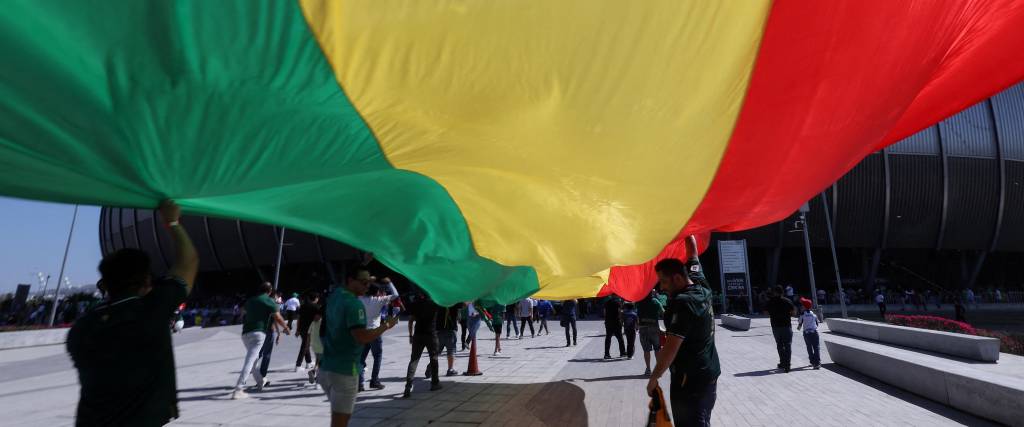 Aficionados bolivianos despliegan una enorme bandera nacional a las afueras del Estadio BBVA.