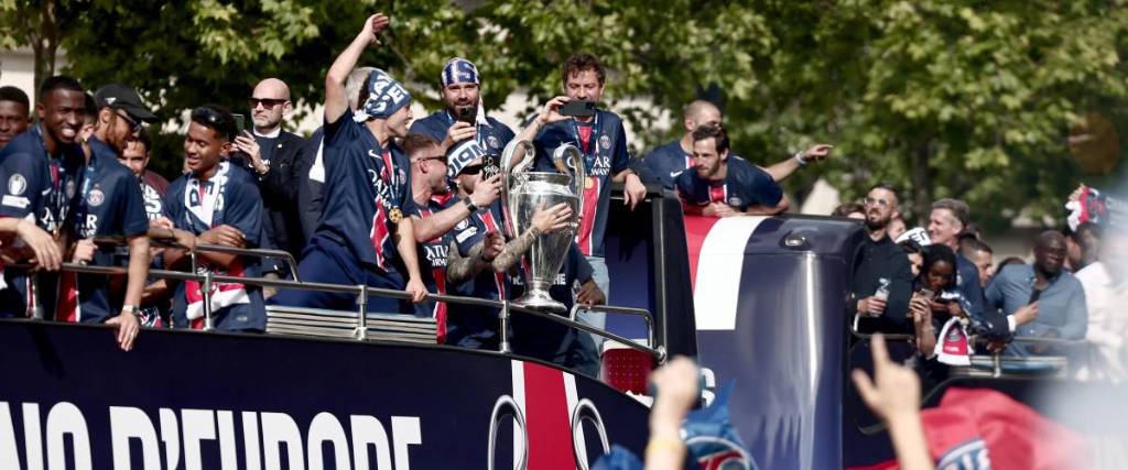 La afición del Paris Saint-Germain saluda mientras el autobús del PSG desfila por la avenida de los Campos Elíseos de París.
