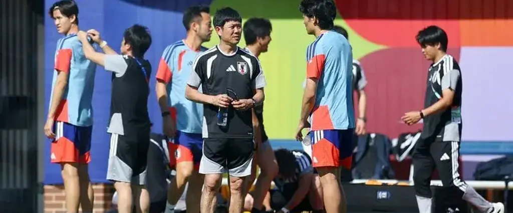 El DT de Japón, Hajime Moriyasu (centro) habla con uno de sus jugadores.