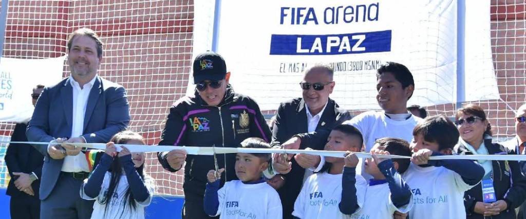 Un niño corta la cinta que inaugura la cancha junto con Costa (centro der.), el alcalde Dockweiler (centro) y Bertoni (izq.), representante de la FIFA.