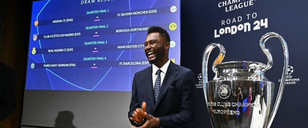 El exfutbolista nigeriano John Obi Mikel posa junto al trofeo después de realizar el sorteo de cuartos de final y semifinales del torneo de fútbol de la Liga de Campeones de la UEFA 2023-2024 este viernes.