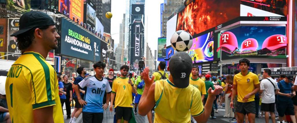Aficionados brasileños juegan con la pelota en el Times Square de Nueva York. 