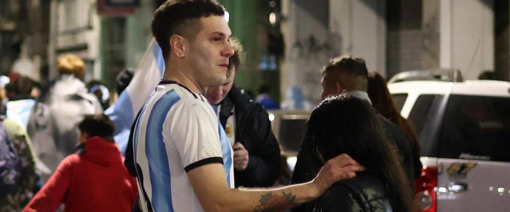 Aficionados argentinos reaccionan tras la derrota de su selección ante España en la final del Mundial.
