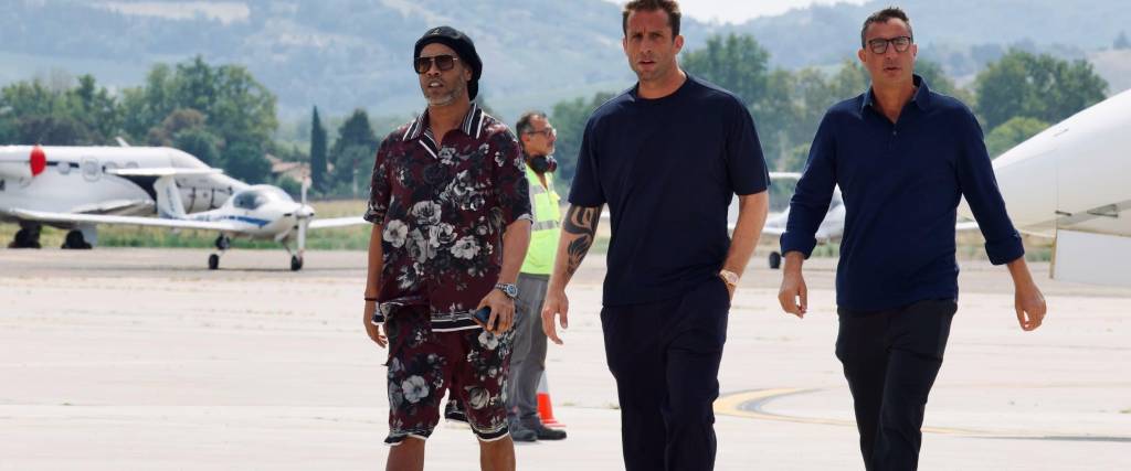 Ronaldinho (izq.) camina junto a los propietarios del club Ravenna de Italia para su presentación oficial.