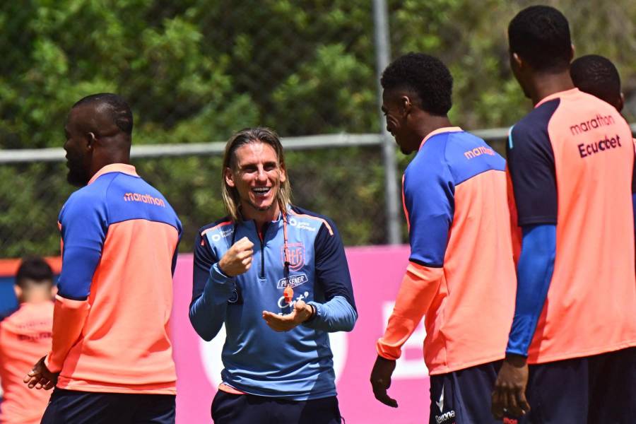 El entrenador argentino de Ecuador, Sebastián Beccacece (C), bromea con los jugadores durante una sesión de entrenamiento de Ecuador.