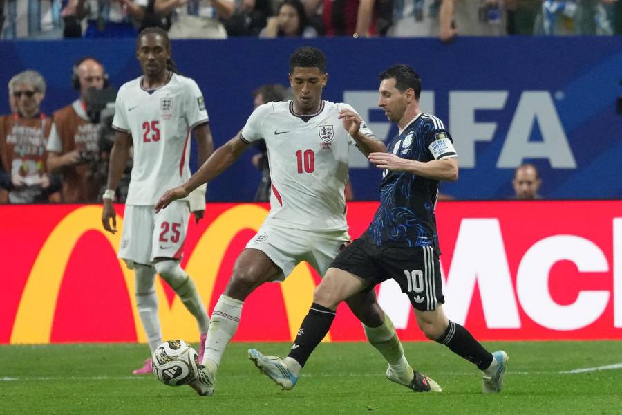 Jude Bellingham (izq.) de Inglaterra disputa el balón con Lionel Messi de Argentina.